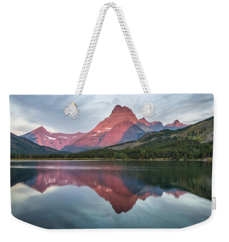 Swiftcurrent Lake Weekender Tote Bag featuring the photograph Reflections on Swiftcurrent Dawn by Greg Nyquist
