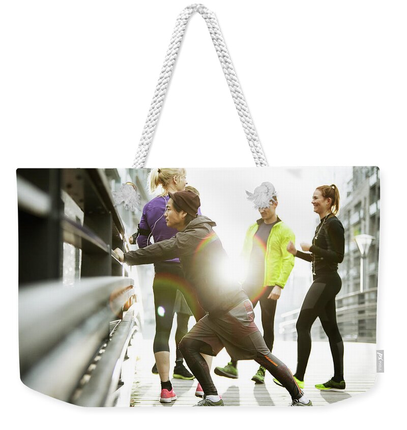 Young Men Weekender Tote Bag featuring the photograph Runners Preparing In Urban Invironment by Henrik Sorensen
