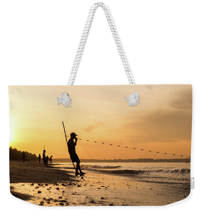 Water's Edge Weekender Tote Bag featuring the photograph Silhouette Of Vietnamese Fishermen by Miha Pavlin
