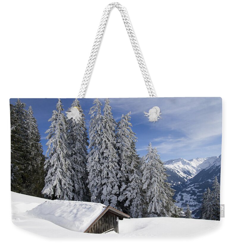 Winter Weekender Tote Bag featuring the photograph Snow covered trees and mountains in beautiful winter landscape by Matthias Hauser