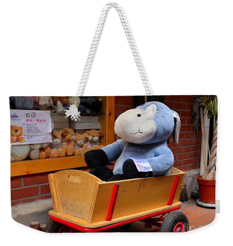 Donkey Weekender Tote Bag featuring the photograph Stuffed donkey toy in wooden barrow cart by Imran Ahmed