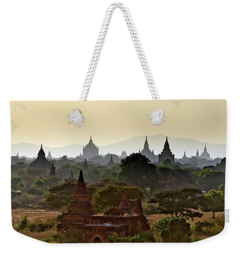 Tranquility Weekender Tote Bag featuring the photograph Temples In Distant Haze At Sunset by Rwp Uk