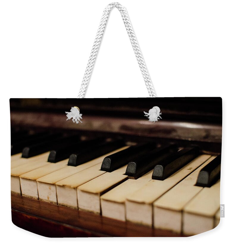 Piano Weekender Tote Bag featuring the photograph Timeworn Piano Keys by Megan Ahrens