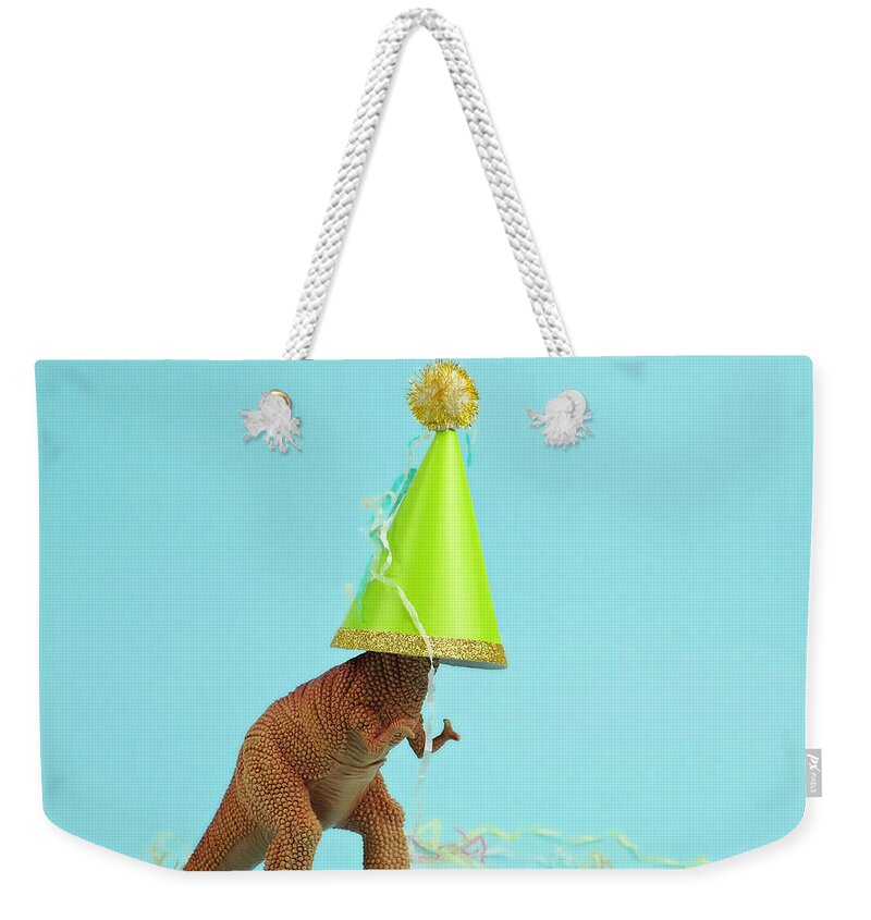Celebration Weekender Tote Bag featuring the photograph Toy Dinosaur Wearing A Party Hat by Juj Winn