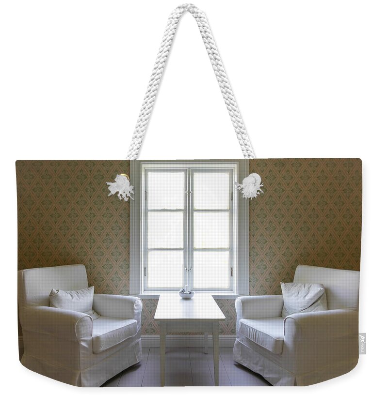 Architecture Weekender Tote Bag featuring the photograph Two Interior Chairs A Table And A Window by Jo Ann Tomaselli