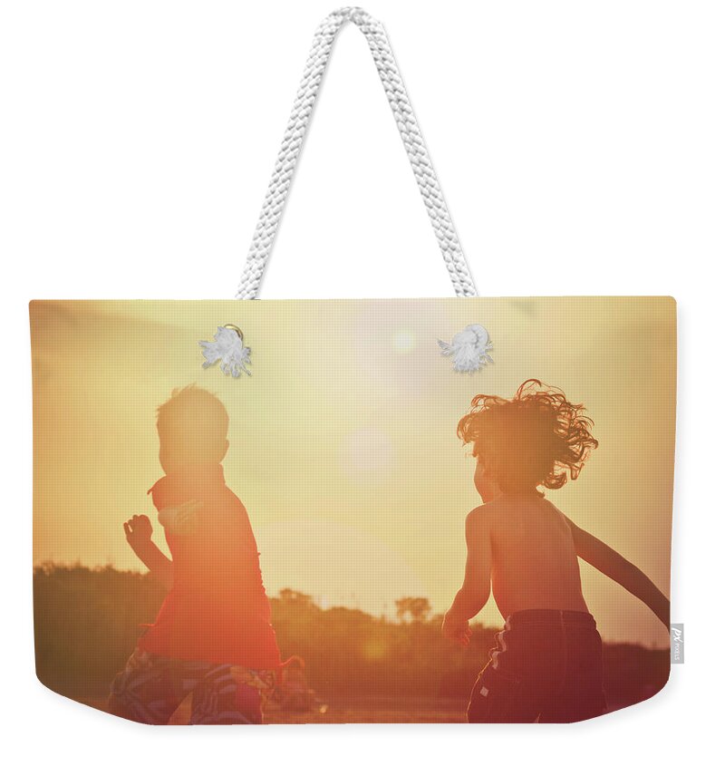 Child Weekender Tote Bag featuring the photograph Two Young Boys Running On The Beach At by Fran Polito