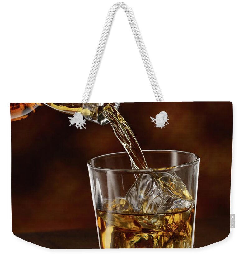 Alcohol Weekender Tote Bag featuring the photograph Whisky Being Poured In A Tumbler, Close by Westend61