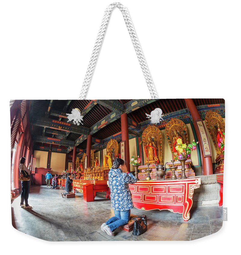 Chinese Culture Weekender Tote Bag featuring the photograph Woman In Front Of Altar, Lama Temple by Peter Adams