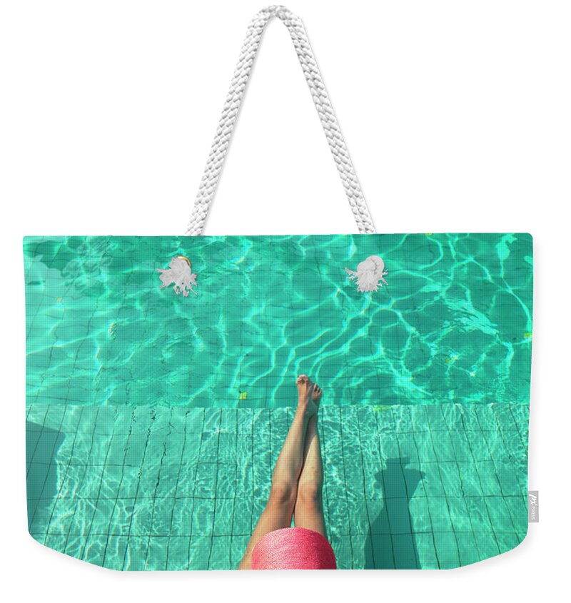 People Weekender Tote Bag featuring the photograph Woman Resting At Edge Of Swimming Pool by Johner Images