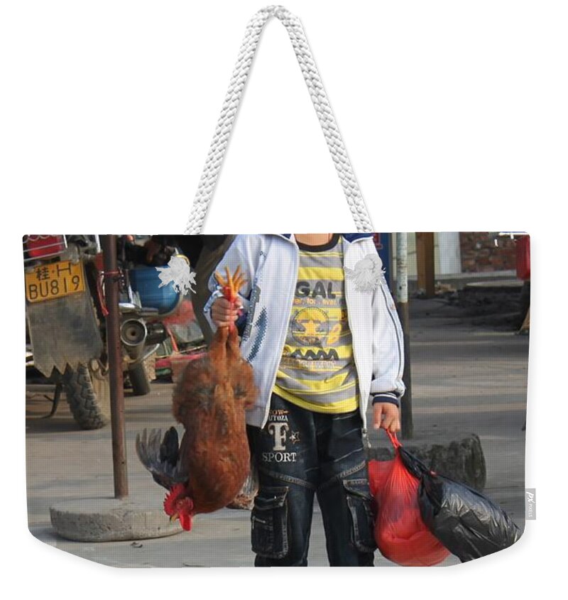 Animal Weekender Tote Bag featuring the photograph Young boy carrying a dead chicken to school by Thomas Marchessault