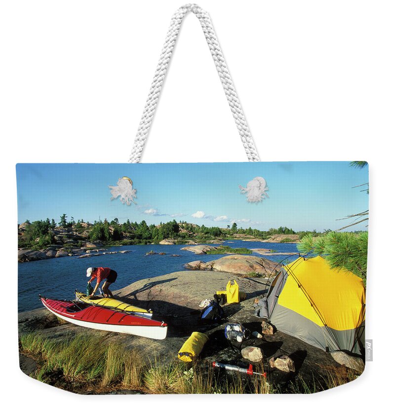 Active Weekender Tote Bag featuring the photograph Young Woman Unloads Sea Kayak While by Henry Georgi