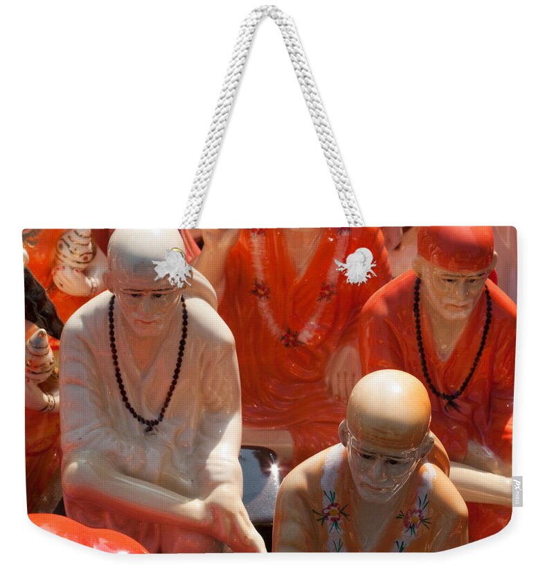 Statues Weekender Tote Bag featuring the photograph A number of statues of The Shirdi Sai Baba for sale at Surajkund Mela by Ashish Agarwal