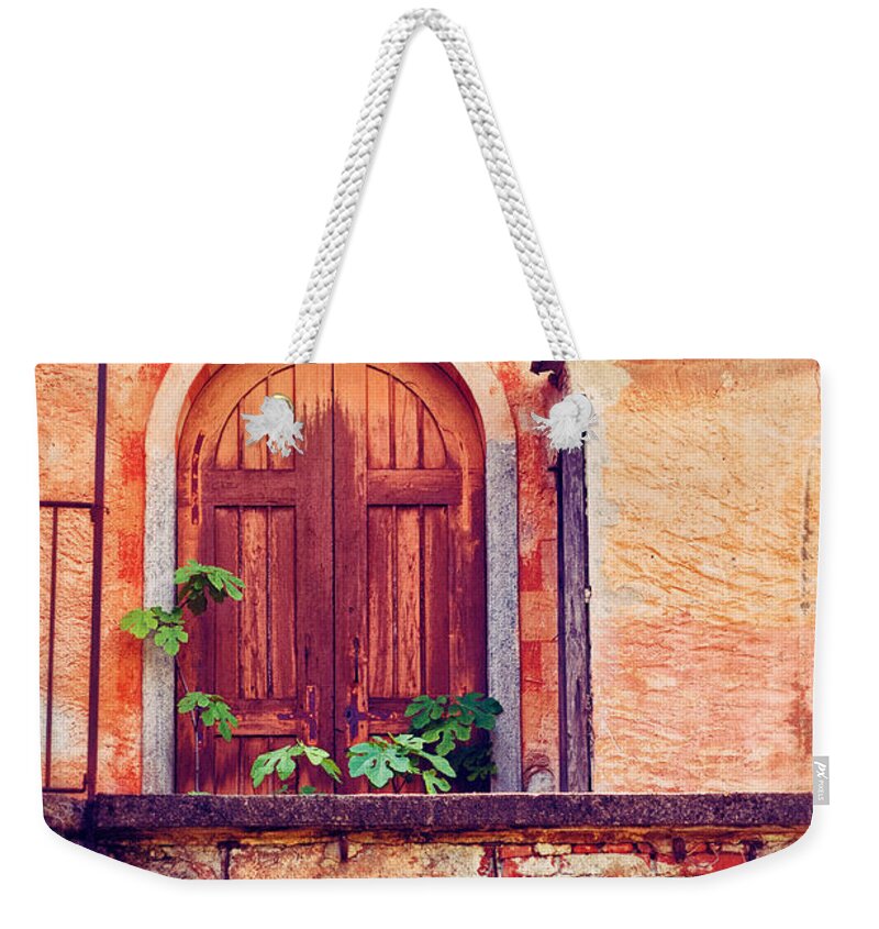 Door Weekender Tote Bag featuring the photograph Abandoned building door with leaves by Silvia Ganora