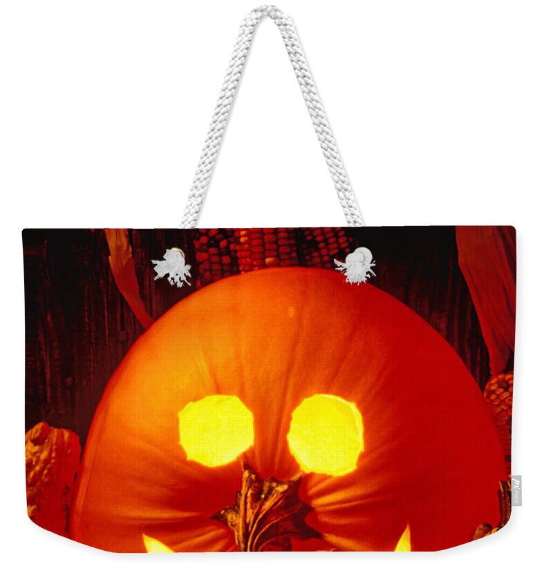 Pumpkin Weekender Tote Bag featuring the photograph Carved pumpkin with fall leaves by Garry Gay