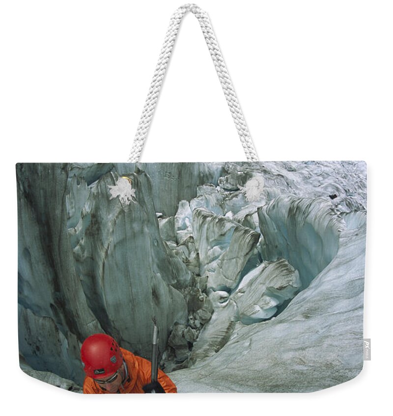 Hhh Weekender Tote Bag featuring the photograph Ice Climber On Steep Ice In Fox Glacier by Colin Monteath