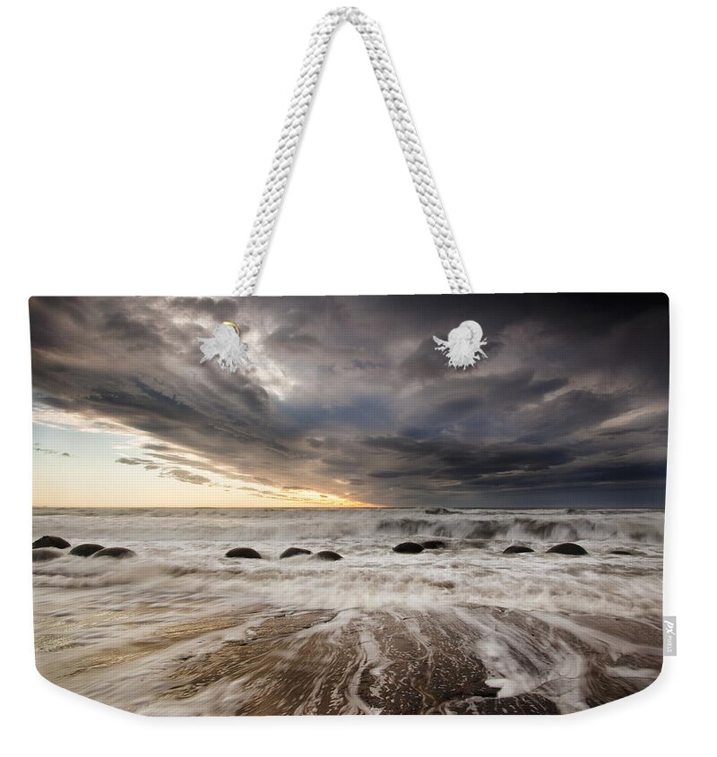 00438713 Weekender Tote Bag featuring the photograph Moeraki Boulders At Dawn With Storm by Colin Monteath