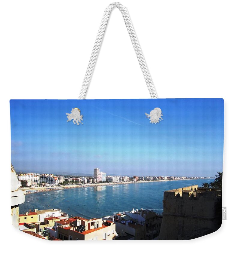 Peniscola Weekender Tote Bag featuring the photograph Peniscola Beach Panoramic View Water Reflection At the Mediterranean Water Front Homes in Spain by John Shiron