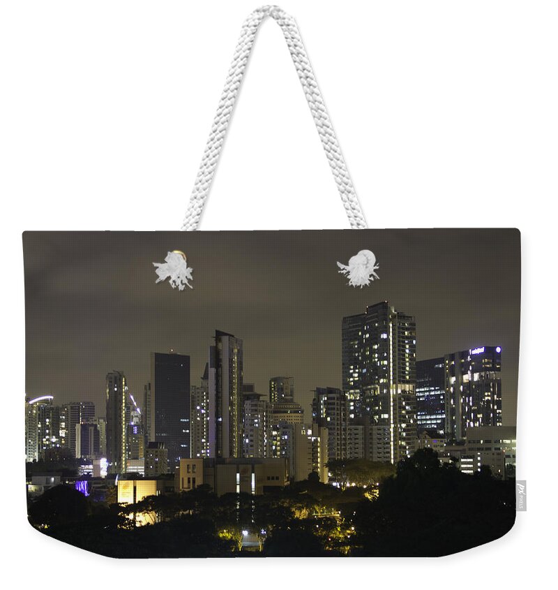 Action Weekender Tote Bag featuring the photograph Skyline of Singapore at night as seen from an apartment complex by Ashish Agarwal