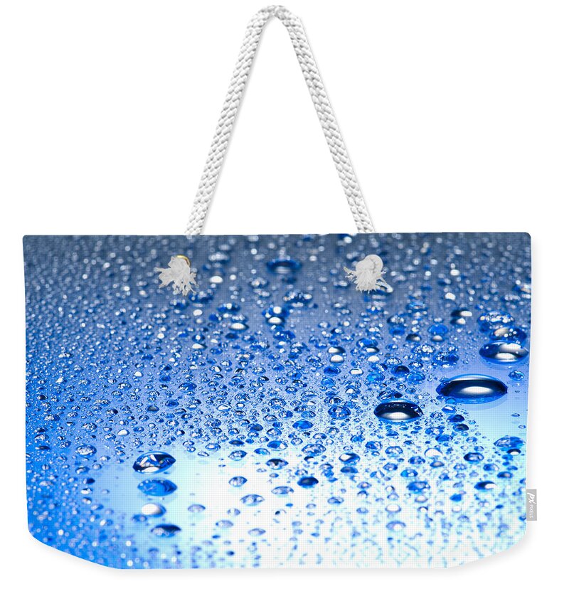 Abstract Weekender Tote Bag featuring the photograph Water drops on a shiny surface by U Schade