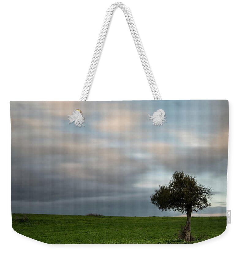 Olive Tree Weekender Tote Bag featuring the photograph Lonely Olive tree with moving clouds #1 by Michalakis Ppalis