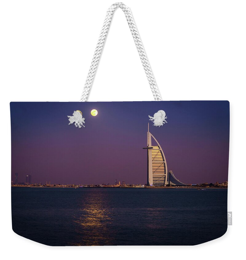 Burj Al Arab Weekender Tote Bag featuring the photograph Moonrise over Burj Al Arab #1 by Alexey Stiop