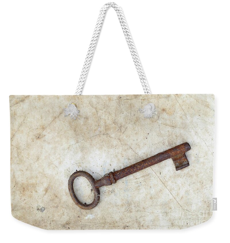 Key Weekender Tote Bag featuring the photograph Rusty key on old parchment #1 by Michal Boubin