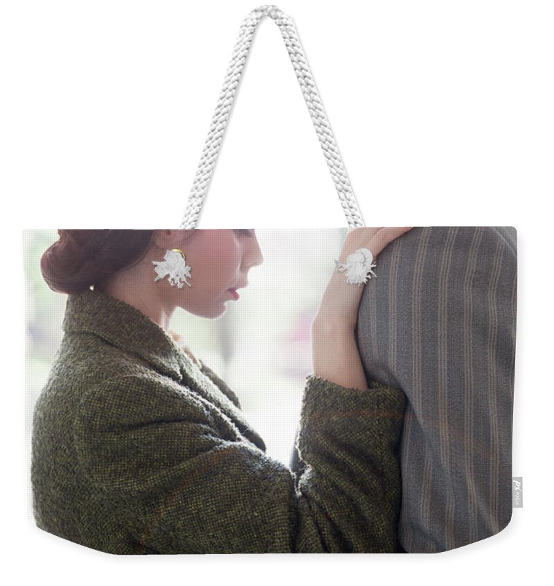 1940s Weekender Tote Bag featuring the photograph Sad 1940s Couple Embracing #1 by Lee Avison