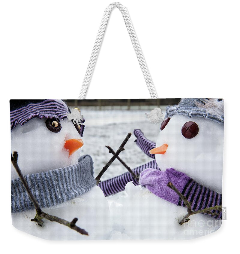 Snowmen Weekender Tote Bag featuring the photograph Two cute snowmen friends embracing #2 by Simon Bratt
