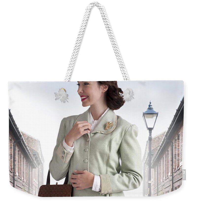 Woman Weekender Tote Bag featuring the photograph 1940s Woman Smiling On A Terraced Street by Lee Avison