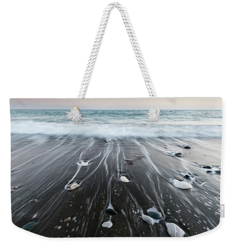 Seascape Weekender Tote Bag featuring the photograph Pebbles in the beach and flowing sea water by Michalakis Ppalis