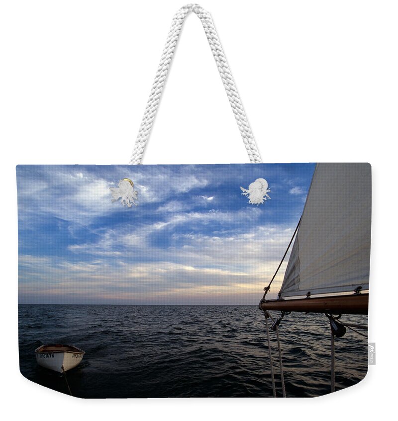 Water Weekender Tote Bag featuring the photograph A Connie Dingy follows a Classic Sailboat by John Harmon