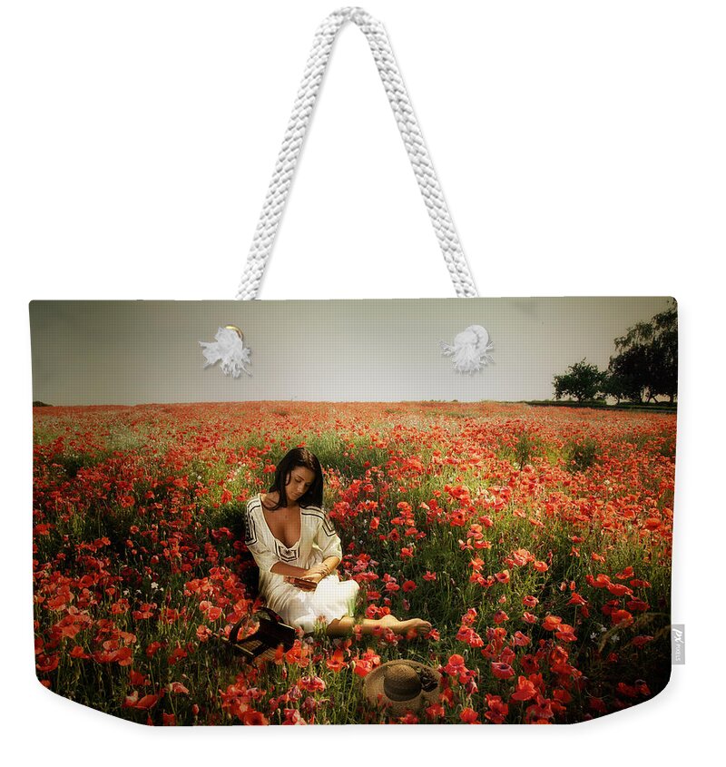 Portrait. Poppies Weekender Tote Bag featuring the photograph A girl reading amongst he Poppies by Mark Egerton