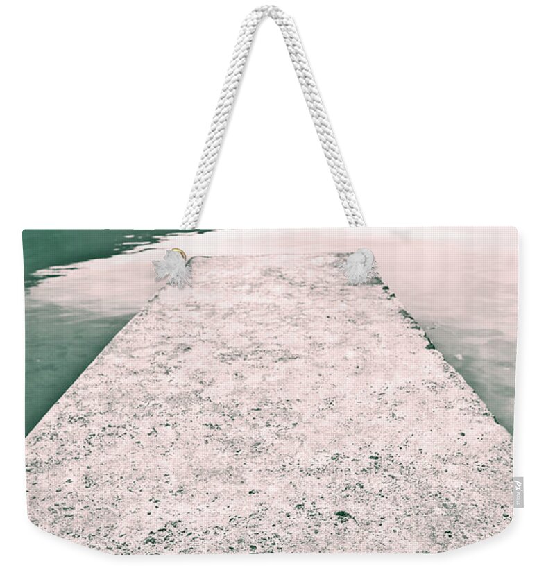 Shoes Weekender Tote Bag featuring the photograph A Pair Of Red Women's Shoes Lying On A Walkway That Leads Into A by Joana Kruse
