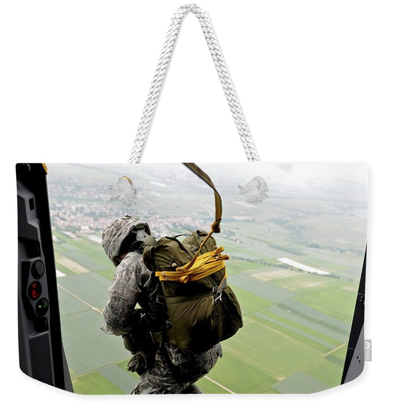 C-17 Globemaster Weekender Tote Bag featuring the photograph A Paratrooper Executes An Airborne Jump by Stocktrek Images