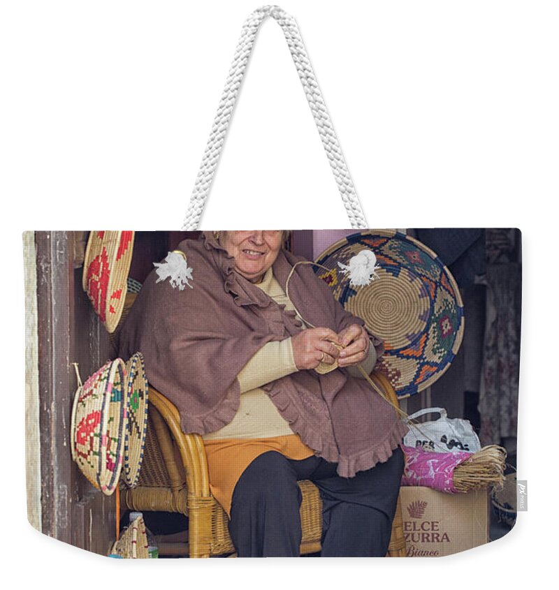Adult Weekender Tote Bag featuring the photograph A woman weaving baskets in Castelsardo by Patricia Hofmeester