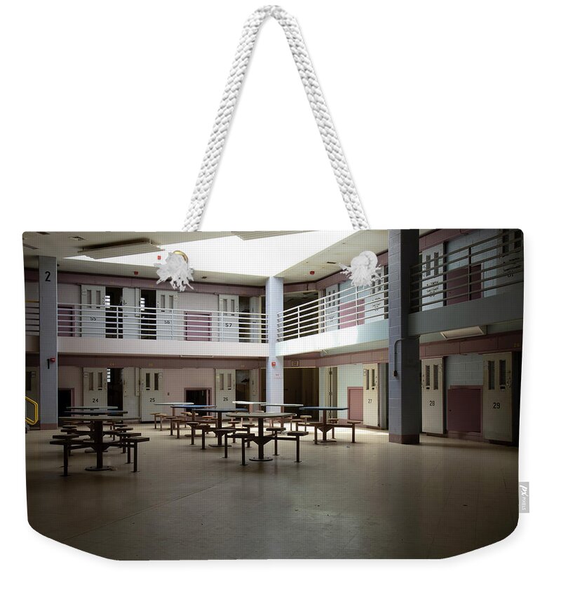 America Weekender Tote Bag featuring the photograph Abandoned jail common room in cell block by Karen Foley