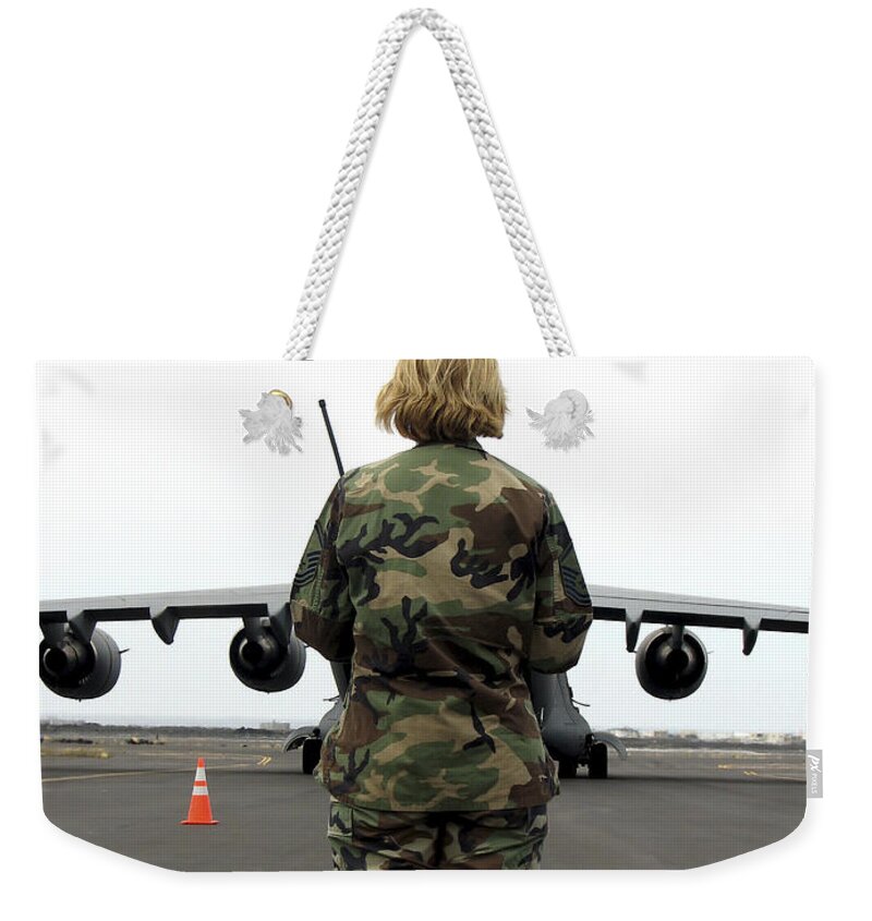 Aeromedical Weekender Tote Bag featuring the photograph An Airfield Manager Greets An Arriving by Stocktrek Images