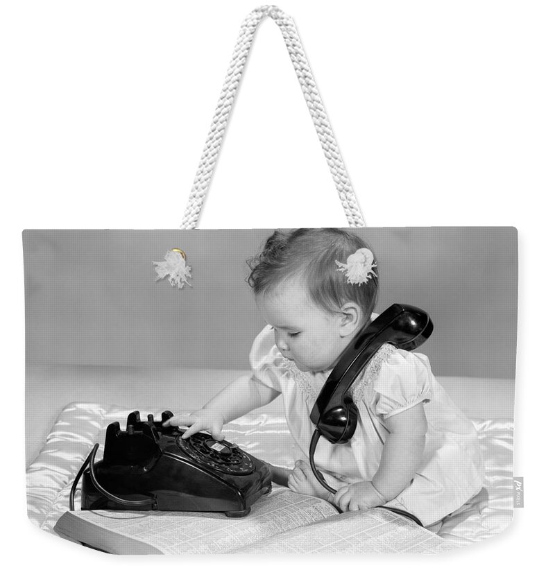 1950s Weekender Tote Bag featuring the photograph Baby With Phonebook And Phone, 1960s by H. Armstrong Roberts/ClassicStock