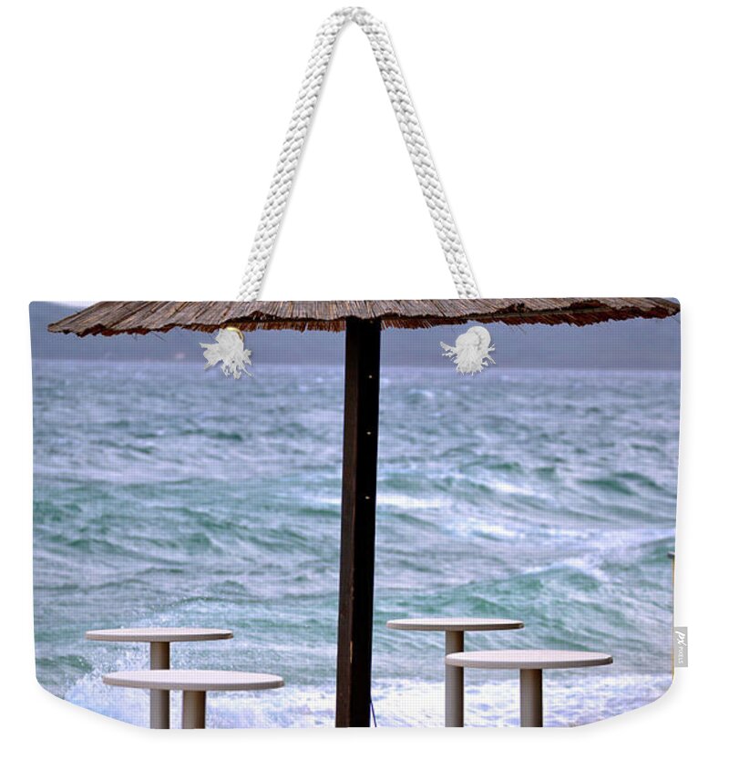 Beach Weekender Tote Bag featuring the photograph Beach bar parasol by rough sea by Brch Photography