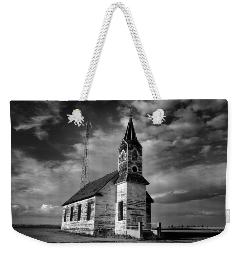 Church Weekender Tote Bag featuring the photograph Black and white of an old church in front of a radio tower  by Jeff Swan