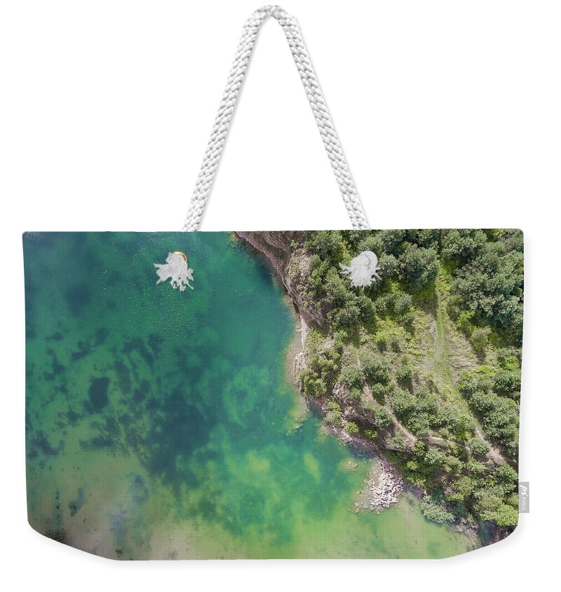 Above Weekender Tote Bag featuring the photograph Blue laggon see from above in old sand mine in Poland. by Mariusz Prusaczyk
