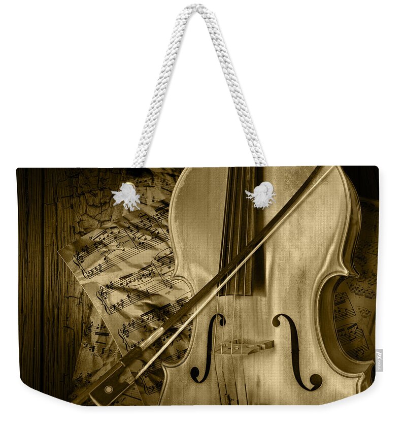 Cello Weekender Tote Bag featuring the photograph Cello Stringed Instrument with Sheet Music and Bow in Sepia by Randall Nyhof