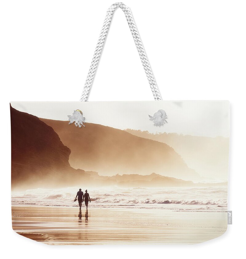Couple Weekender Tote Bag featuring the photograph Couple Walking On Beach With Fog by Mikel Martinez de Osaba