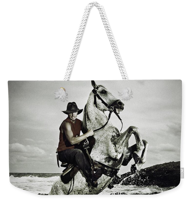Horse Weekender Tote Bag featuring the photograph Cowboy on the rear up horse in the river by Dimitar Hristov