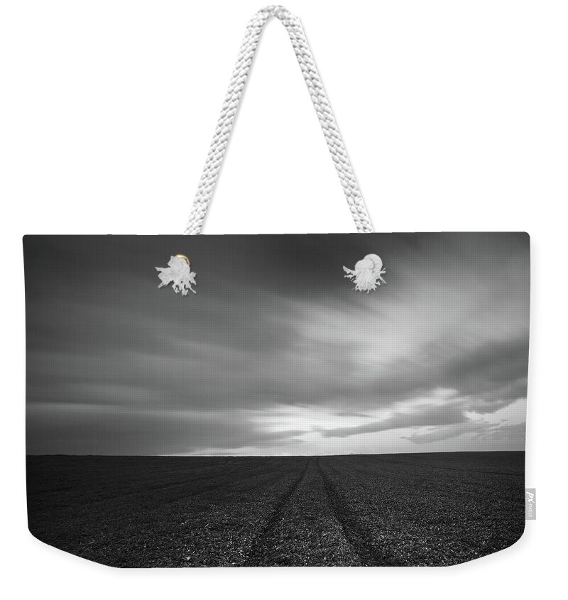 Field Weekender Tote Bag featuring the photograph Field and cloudy sky by Michalakis Ppalis