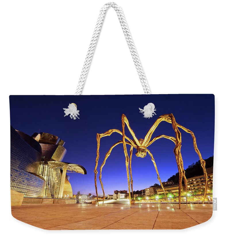 Guggenheim Weekender Tote Bag featuring the photograph Guggenheim museum and spider at night in Bilbao by Mikel Martinez de Osaba