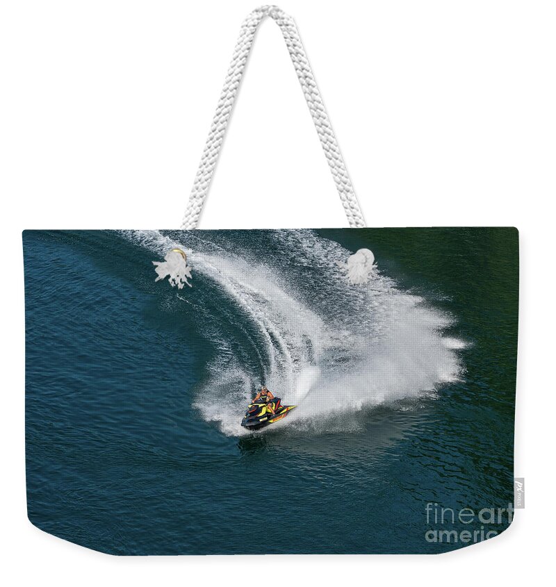 Jet Weekender Tote Bag featuring the photograph Jet ski on a dark blue water by Les Palenik