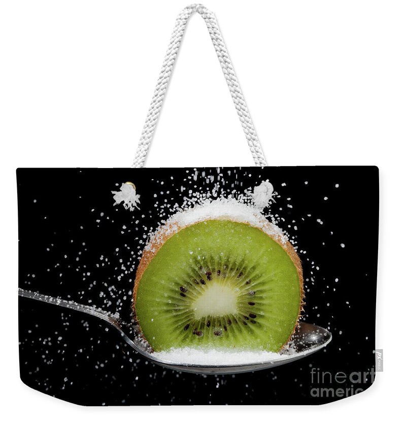 Kiwi Weekender Tote Bag featuring the photograph Kiwi fruit cut in half on a spoon with sugar by Simon Bratt