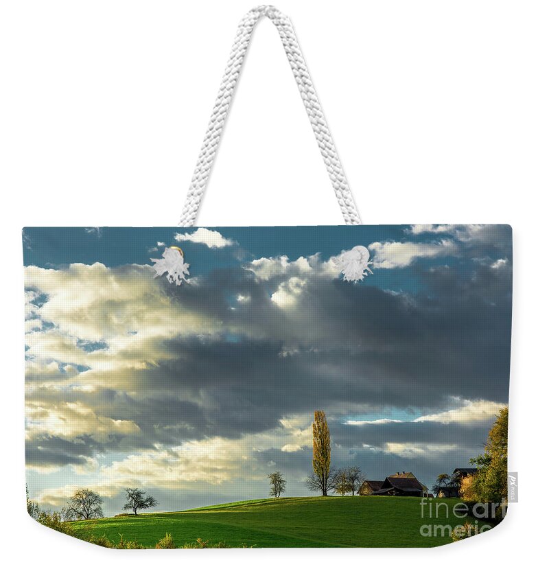Landscape Weekender Tote Bag featuring the photograph Landscape With House and Sunlit Hill in Austria by Andreas Berthold