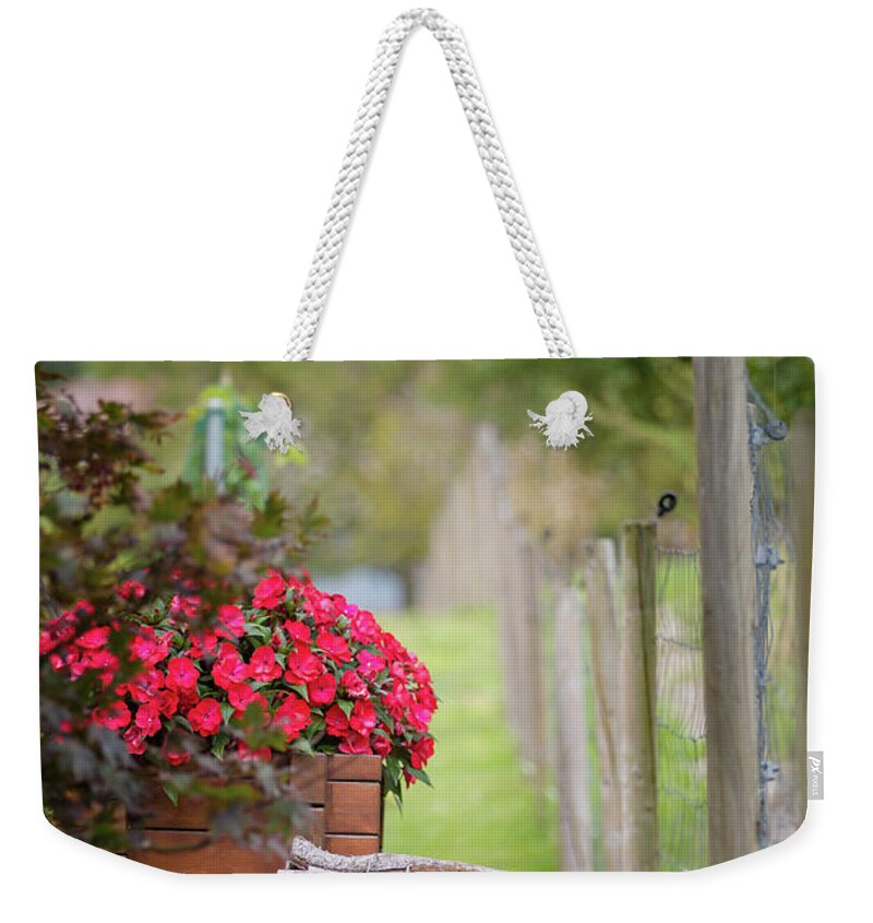 Country Weekender Tote Bag featuring the photograph Red flowerd with Fende and wood billet bundle by Amanda Mohler